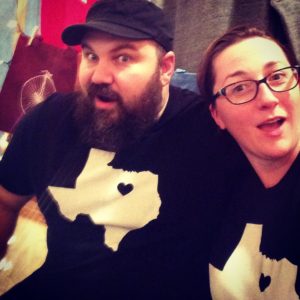 A man and a woman wearing Texas tshirts smile at the camera.